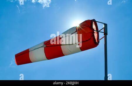 Calzino per vento. Bandiera Windsock. Indicatore di direzione del vento. Intensità del vento. Windsock di fronte al cielo blu. Foto Stock