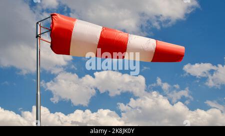 Calzino per vento. Bandiera Windsock. Indicatore di direzione del vento. Intensità del vento. Windsock di fronte al cielo blu. Foto Stock