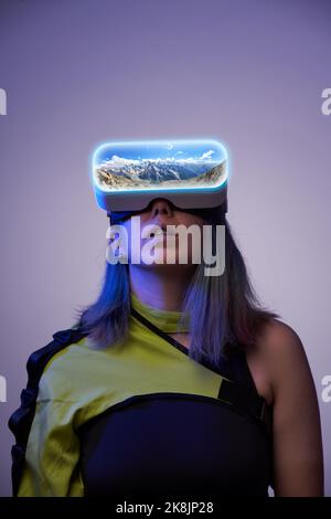 La donna usa gli occhiali di realtà virtuale per andare ad un altro punto del mondo. Il concetto di realtà virtuale, simulazione e tecnologie future. Foto Stock