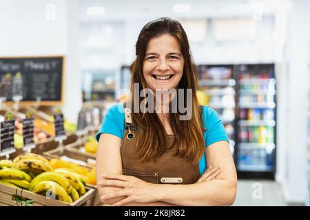 Donna felice che lavora all'interno del supermercato Foto Stock