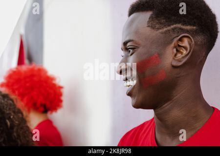 Tifosi africani che si divertono a supportare la sua squadra preferita: Il concetto di intrattenimento sportivo Foto Stock