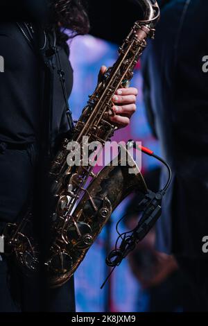 Sassofono soprano in mani su sfondo scuro. Primo piano dello strumento musicale Alto sax Foto Stock