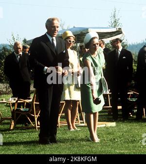 Flå 19690811. Regina Elisabetta in Norvegia con la famiglia. Il primo Ministro per Borten ha invitato la Regina per il pranzo nella sua casa nella fattoria di Flå. Qui vediamo per Borten imparare la Regina a giocare Boccia. Crown Princess Sonja è sullo sfondo con cappello giallo e occhiali da sole gialli. La regina in abito estivo verde, cappello bianco. Serio, concentrato. Foto: Archivio NTB Foto Stock