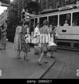 Oslo 8 agosto 1959. La relazione "incinta sulla città" era in corso nel 1959. Hanno equipaggiato una donna incinta con pacchetti e borse per vedere se le è stato offerto aiuto. Poco è cambiato in 40 anni, nessun aiuto per ottenere. Al tram è stata a lungo offerto un posto a sedere. E in un caffè affollato, dopo un po' le fu offerto di sedersi al tavolo di una sorella. Qui fino a Karl Johansgate, il tram per la partita oscilla da Rosenkrantzgate. Foto: Bjørn Bjørnsen / corrente / NTB Foto Stock