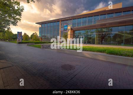 Indianapolis, IN—6 settembre 2022; nuvole e cielo tramonto dietro un moderno edificio di vetro con segni che lo designano come sede della National Collegiate Foto Stock