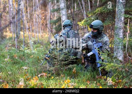 Ämari, Estonia. 24 ottobre 2022, Estonia, Ämari: Soldati delle forze armate tedesche si accovacciano in una zona boschiva durante un esercizio presso la base aerea di Ämari. Le forze aeree e gli ispettori della Marina visitano l'Estonia per la manovra della Tigre Baltica 2022, lunga quasi un mese. Le unità della Marina militare e dell'Aeronautica militare praticano la protezione delle infrastrutture critiche sul fianco orientale della NATO in Estonia. Foto: Christophe Gateau/dpa Credit: dpa picture Alliance/Alamy Live News Foto Stock