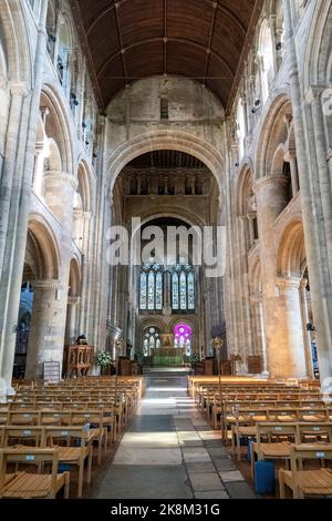 Interno di Romsey Abbey, una chiesa normanna nella città di Romsey, Hampshire, Inghilterra, Regno Unito. Vista dell'altare maggiore, vetrata e navata centrale Foto Stock