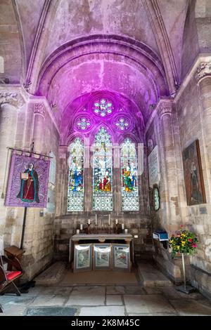 Interno di Romsey Abbey, una chiesa normanna nella città di Romsey, Hampshire, Inghilterra, Regno Unito. Vista dell'altare maggiore, vetrata e navata centrale Foto Stock