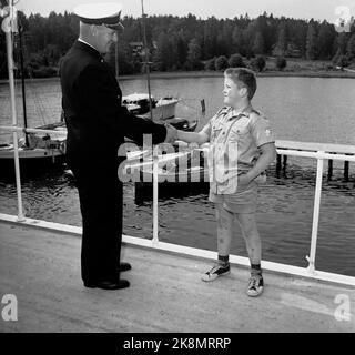 Hankø nell'estate del 1956. Registrazione del primo lungometraggio norvegese a colori, intitolato 'Smugglers in tuxedo'. Qui, il giovane attore Andreas Diesen saluta uno dei rappresentanti del Servizio doganale, che ha messo a disposizione delle riprese. Andreas è il figlio di Ernst Diesen che gioca il ruolo del tenente colonnello Brusefjær nel film. Andreas nel ruolo di Lille-Bertram. Foto: Aage Storløkken / corrente / NTB. Foto Stock