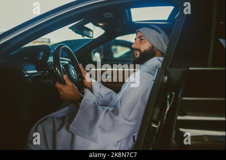 Uomo Saudita che guida una macchina e si sente bene Foto Stock