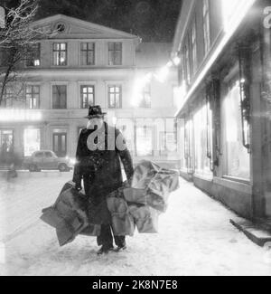 Arvika, Svezia 195412. Le casalinghe norvegesi hanno conquistato Arvika. Nel mese di dicembre, la città è stata invasa fino a 20 autobus norvegesi imballati da casalinghe shopping di Natale. Lunghe code di casalinghe nel negozio coloniale e il negozio di giocattoli per acquistare a buon mercato ciò di cui hanno bisogno per Natale. Alcuni giorni ci sono fino a 6-700 donne di shopping di Natale. Qui vediamo un uomo con molti pacchetti che hanno anche fatto il loro modo in Svezia per acquistare cibo a buon mercato. Foto: Aage Storløkken / corrente / NTB Foto Stock