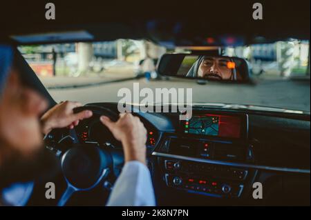 Uomo Saudita che guida una macchina e si sente bene Foto Stock