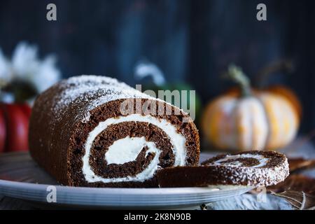 Torta rotonda di zucca al cioccolato appena sfornata con zucchero a velo e ripieno di formaggio cremoso. Messa a fuoco selettiva con sfondo sfocato in primo piano. Foto Stock