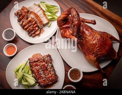 Deliziosa anatra alla pechinese e maiale arrosto servito con salse e cetrioli freschi Foto Stock