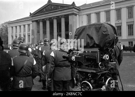 Oslo 19650222 dalla registrazione del film 'Heroes from Telemark' / 'Heroes of Telemark' sul sabotaggio dell'acqua pesante. Qui dalla registrazione presso la Piazza dell'Università di Oslo. Un'orchestra militare tedesca con uniformi e caschi si scaccia sulla piazza, con una squadra di telecamere dopo di loro. Foto: Erik Thorberg / NTB / NTB Foto Stock