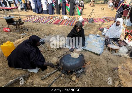 Gaza, Palestina. 23rd Ott 2022. Le donne palestinesi cuocono pane tradizionale partecipando a una celebrazione della stagione della raccolta delle olive in una fattoria a Deir al-Balah nella striscia centrale di Gaza. Credit: SOPA Images Limited/Alamy Live News Foto Stock