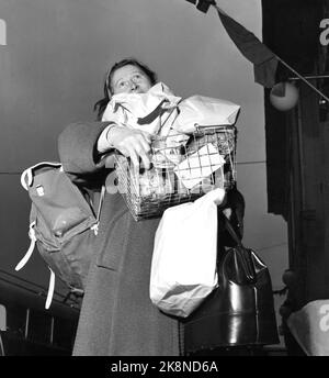 Arvika, Svezia 195412. Le casalinghe norvegesi hanno conquistato Arvika. Nel mese di dicembre, la città è stata invasa fino a 20 autobus norvegesi imballati da casalinghe shopping di Natale. Lunghe code di casalinghe nel negozio coloniale e il negozio di giocattoli per acquistare a buon mercato ciò di cui hanno bisogno per Natale. Alcuni giorni ci sono fino a 6-700 donne di shopping di Natale. Qui vediamo una casalinga di Oslo sulla via d'uscita della medaglia di vita di Wikstrøm, dove ha fatto un bene all'ingrosso. In questo negozio sono richiesti frutti del sud in scatola. Foto: Aage Storløkken / corrente / NTB Foto Stock