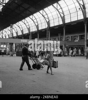 Oslo 8 agosto 1959. La relazione "incinta sulla città" era in corso nel 1959. Hanno equipaggiato una donna incinta con pacchetti e borse per vedere se le è stato offerto aiuto. Poco è cambiato in 40 anni, nessun aiuto per ottenere. Al tram è stata a lungo offerto un posto a sedere. E in un caffè affollato, dopo un po' le fu offerto di sedersi al tavolo di una sorella. Qui dalla vecchia sala ferroviaria est, ora stazione centrale di Oslo. Foto: Bjørn Bjørnsen / corrente / NTB Foto Stock