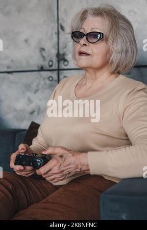 Ritratto di una donna la cui età non la preoccupa di sentirsi giovane, giocando con la sua figlia matura in videogiochi che trascorrono del tempo insieme. Riposo, relax Foto Stock