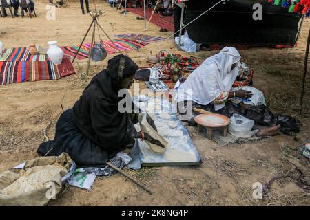 Gaza, Palestina. 23rd Ott 2022. Le donne palestinesi cuocono pane tradizionale partecipando a una celebrazione della stagione della raccolta delle olive in una fattoria a Deir al-Balah nella striscia centrale di Gaza. (Foto di Yousef Masoud/SOPA Images/Sipa USA) Credit: Sipa USA/Alamy Live News Foto Stock