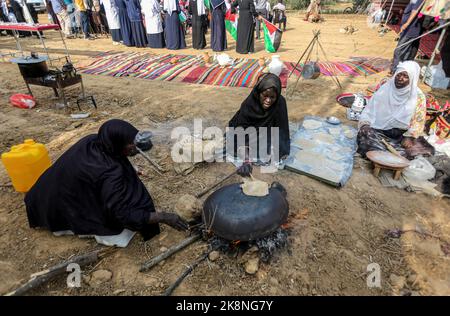 Gaza, Palestina. 23rd Ott 2022. Le donne palestinesi cuocono pane tradizionale partecipando a una celebrazione della stagione della raccolta delle olive in una fattoria a Deir al-Balah nella striscia centrale di Gaza. (Foto di Yousef Masoud/SOPA Images/Sipa USA) Credit: Sipa USA/Alamy Live News Foto Stock