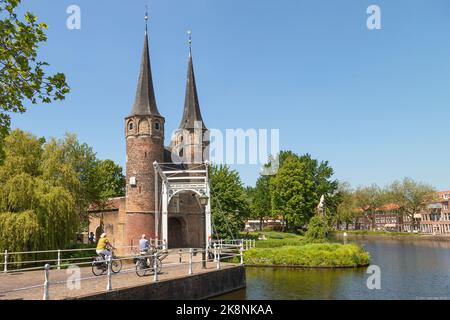 Porta della città 'De Oostpoort' e un ponte levatoio bianco sul bordo della pittoresca cittadina di Delft. Foto Stock