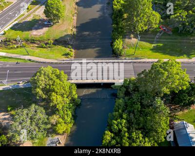 Ripresa aerea verso il basso del ponte sul fiume tropicale che attraversa il Queensland nord Foto Stock