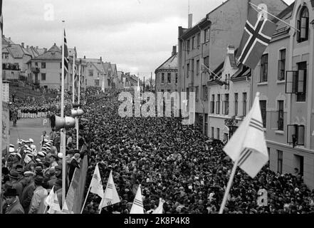 Ålesund 19480413: 100th° anniversario della città di Ålesund. L'anniversario è stato segnato in molti modi. La pioggia non ha smorzato l'atmosfera della festa. Qui, migliaia di persone hanno trovato la strada per il sito della mostra (TV) e Kippervikgata. Le bandiere norvegesi e la bandiera della città di Ålesund decorano le strade. Foto: Corrente / NTB Foto Stock