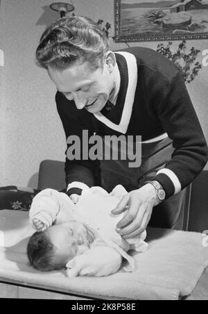 Trondheim 19500204. Stella del pattinaggio Hjalmar Andersen 'Hjallis' (27 anni) con la sua famiglia a Trondheim. Il tempo rimasto dopo il lavoro di camionista e lo sport ha avuto il suo proprio. Hjalmar Andersen ha due bambini qui è il più piccolo che ha due mesi che cambia i pannolini appena come è. È il lavoro della moglie, ma pensa che sia bello aiutare. Foto: Sverre A. Børresen corrente / NTB Foto Stock