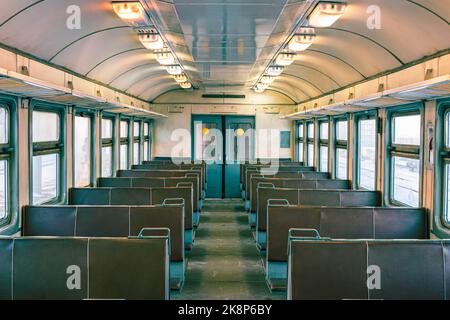 Cabina vuota del vecchio treno elettrico passeggeri. Sedili vuoti in pelle cabina treno, corridoio, non persone Foto Stock