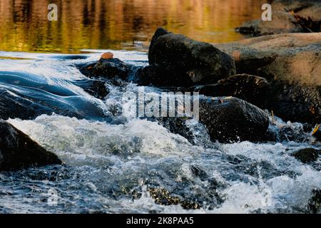 Acqua turbolenta, fiume calmo e riflessi rossi e verdi. Foto Stock