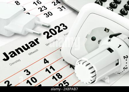 Deutscher Kalender Januar 2023 mit Steckdose, Rechner und Heizungstermostato im Winter Foto Stock