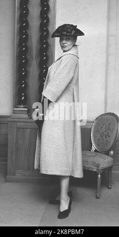 Oslo 19560223. Moda primavera ed estate 1956. Spettacolo di manichini di abiti da donna prodotti in Norvegia. Cappotto dalla silkhouse. Si ispira a Jean Desses, il tessuto è grossolano in lana grigia e bianca. Braccio laterale in legno, alimentazione nera e così sono gli accessori come scarpe, guanti lunghi e cappello. Foto: Aage Storløkken / Kaare Nymark / NTB Foto Stock