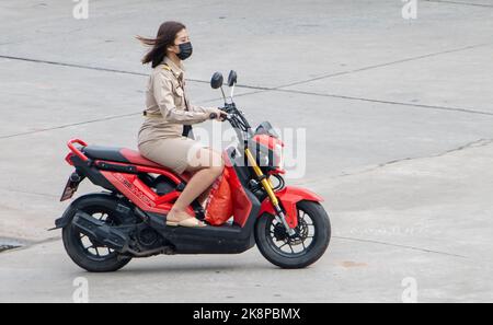 SAMUT PRAKAN, THAILANDIA, ottobre 03 2022, Una donna in uniforme di un funzionario guida una moto Foto Stock