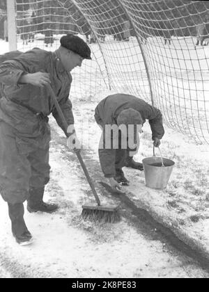 Oslo 19471115. Calcio in tempo nevoso a Bislett. La partita di calcio tra Dynamo e Skeid è stata disputata in inverno. Prima e durante la partita nevicava strettamente, e il manto erboso era bianco e duro. 32.000 spettatori sono un record a Bislett. Nella neve fresca, i margini bianchi non sono utili. Sia prima che durante la pausa tra i giri, la gente della pista spruzzerà la farina rossa del campo da tennis sulle linee per contrassegnarle. Foto: Corrente / NTB Foto Stock