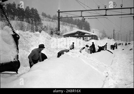 Nelaug stazione 19510207: Forte nevicata sulla parte meridionale del paese ha creato caos nel traffico ferroviario. In totale, cinque treni sono rimasti bloccati nelle masse di neve alle stazioni di Helldalsmo e Nelaug, e i passeggeri hanno dovuto trascorrere la notte in treni ghiacciati. Qui ci sono molte persone che lavorano con la neve di gulling alla stazione di Nerlaug. Foto: NTB / NTB Foto Stock