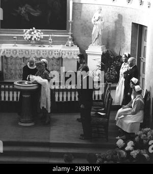 Oslo 19570424 la principessa Ragnhild la signora Lorentzen e gli altri figli dell'armatore Erling Lorentzen sono battezzati nella cappella del castello dal vescovo Eivind Berggrav. Fu battezzata Ingeborg dopo sua nonna. Al fonte battesimale: Nonna Principessa Ingeborg con il bambino battesimo, dietro la Principessa Ragnhild, e il Vescovo Berggrav. Poi contro H: Il principe Harald e Erling Lorentzen, la signora Ingjerd Lie e l'armatore Øivind Lorentzen. I due infermieri si chiamano Olaug Haugen ed altro Strandlie. Foto: NTB / NTB Foto Stock