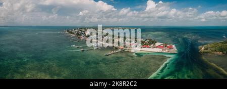 Una splendida vista aerea dello Spalato in Caye Caulker, Belize con acqua turchese sotto un cielo nuvoloso Foto Stock