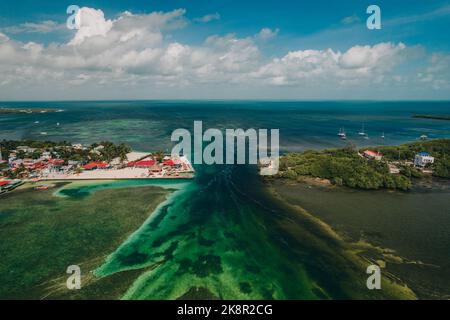 Una splendida vista aerea dello Spalato in Caye Caulker, Belize con acqua turchese sotto un cielo nuvoloso Foto Stock
