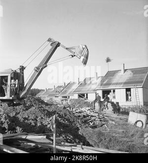 Bærum. Nadderud 1951. 48 case sono in costruzione su Nadderud. 'Si parla di case cittadine all'uno e mezzo piano con arredamento secondo i principi americani. Ogni appartamento è composto da 4 camere e cucina, con una superficie totale di ​​115 mq, oltre al seminterrato sotto la metà della casa. L'affitto sarà di 160.- kroner al mese. Ma può probabilmente essere ridotto. La caparra è stimata a 7.000 NOK per appartamento. ' Ecco un vecchio escavatore di fronte alle case. Foto: Sverre A. Børretzen / NTB Foto Stock