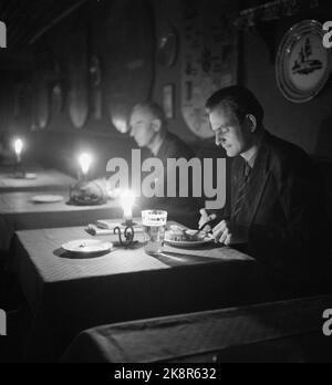 Oslo 19471101. Un'ora di razionamento a Oslo dopo l'estate secca con un calore record. Il collegamento all'alimentazione è disponibile ogni mattina dalle 2:11,30 alle 12,30:00. Il distacco comporta una significativa interruzione del lavoro delle aziende che dipendono dall'elettricità alle loro macchine. È Oslo Lysverker che distribuisce la corrente. Qui dal Ristorante Blom con candele che creano un ambiente più bello, caldo e intimo. Foto: TH. Corrente Scotaam / NTB Foto Stock