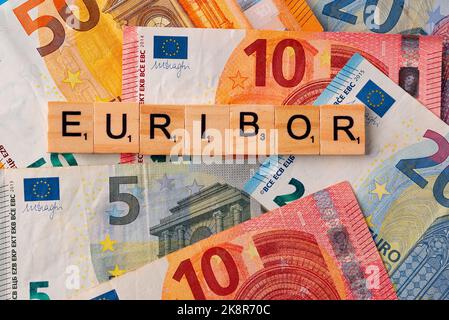 La parola Euribor è scritta in lettere di legno sullo sfondo delle banconote in euro. Copia incolla. Foto Stock