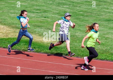 Russia. Vyborg 06.06.2021 bambini corrono lungo la pista dello stadio in estate. Foto di alta qualità Foto Stock