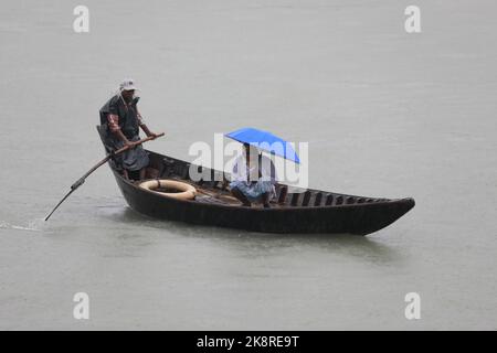 Dhaka, Bangladesh. 24th Ott 2022. I passeggeri del Bangladesh attraversano il fiume Buriganga mentre detengono ombrelli durante una forte pioggia e condizioni difficili causate dal ciclone Sitrang a Dhaka, Bangladesh, 24 ottobre 2022. Secondo la Bangladesh Inland Water Transport Authority (BIWTA) e il Dipartimento di Meteorologia del Bangladesh, il trasporto di acque interne è stato sospeso in quanto il ciclone Sitrang si avvicina dovrebbe attraversare la parte sud-sud-ovest del distretto di Barishal e Chattogram entro il 25 ottobre. Il Bangladesh Met Office ha avvertito che la tempesta ciclonica potrebbe intensificarsi ulteriormente e trasformarsi in un grave ciclone Foto Stock