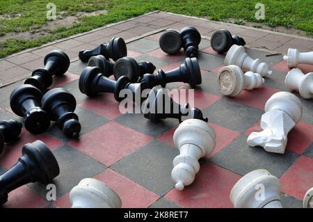 Pezzi di scacchi che sono stati abbattuti su un set di scacchi Mega. Foto Stock