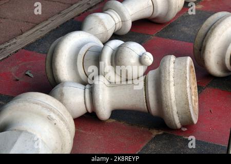 Fallen White Pawns su un grande scacchiera all'aperto Foto Stock