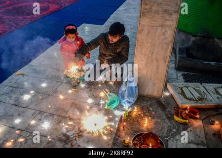 Srinagar, India. 24th Ott 2022. I devoti indù illuminano cracker di fuoco al tempio alla vigilia di Diwali, il festival indù delle luci, a Srinagar. Deepavali o Dipavali è una festa di luci di quattro-cinque giorni, che viene celebrata dagli Indù in ogni autunno in tutto il mondo. Credit: SOPA Images Limited/Alamy Live News Foto Stock
