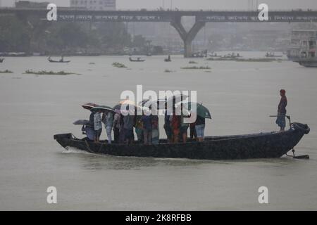 Dhaka, Bangladesh. 24th Ott 2022. I passeggeri del Bangladesh attraversano il fiume Buriganga mentre detengono ombrelli durante una forte pioggia e condizioni difficili causate dal ciclone Sitrang a Dhaka, Bangladesh, 24 ottobre 2022. Secondo la Bangladesh Inland Water Transport Authority (BIWTA) e il Dipartimento di Meteorologia del Bangladesh, il trasporto di acque interne è stato sospeso in quanto il ciclone Sitrang si avvicina dovrebbe attraversare la parte sud-sud-ovest del distretto di Barishal e Chattogram entro il 25 ottobre. Il Bangladesh Met Office ha avvertito che la tempesta ciclonica potrebbe intensificarsi ulteriormente e trasformarsi in un grave ciclone Foto Stock