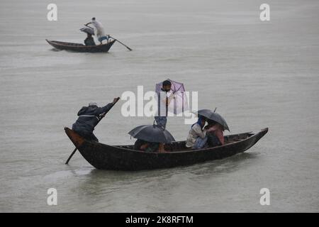 Dhaka, Bangladesh. 24th Ott 2022. I passeggeri del Bangladesh attraversano il fiume Buriganga mentre detengono ombrelli durante una forte pioggia e condizioni difficili causate dal ciclone Sitrang a Dhaka, Bangladesh, 24 ottobre 2022. Secondo la Bangladesh Inland Water Transport Authority (BIWTA) e il Dipartimento di Meteorologia del Bangladesh, il trasporto di acque interne è stato sospeso in quanto il ciclone Sitrang si avvicina dovrebbe attraversare la parte sud-sud-ovest del distretto di Barishal e Chattogram entro il 25 ottobre. Il Bangladesh Met Office ha avvertito che la tempesta ciclonica potrebbe intensificarsi ulteriormente e trasformarsi in un grave ciclone Foto Stock