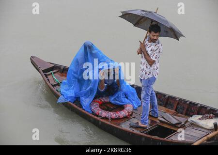 Dhaka, Bangladesh. 24th Ott 2022. I passeggeri del Bangladesh attraversano il fiume Buriganga mentre detengono ombrelli durante una forte pioggia e condizioni difficili causate dal ciclone Sitrang a Dhaka, Bangladesh, 24 ottobre 2022. Secondo la Bangladesh Inland Water Transport Authority (BIWTA) e il Dipartimento di Meteorologia del Bangladesh, il trasporto di acque interne è stato sospeso in quanto il ciclone Sitrang si avvicina dovrebbe attraversare la parte sud-sud-ovest del distretto di Barishal e Chattogram entro il 25 ottobre. Il Bangladesh Met Office ha avvertito che la tempesta ciclonica potrebbe intensificarsi ulteriormente e trasformarsi in un grave ciclone Foto Stock